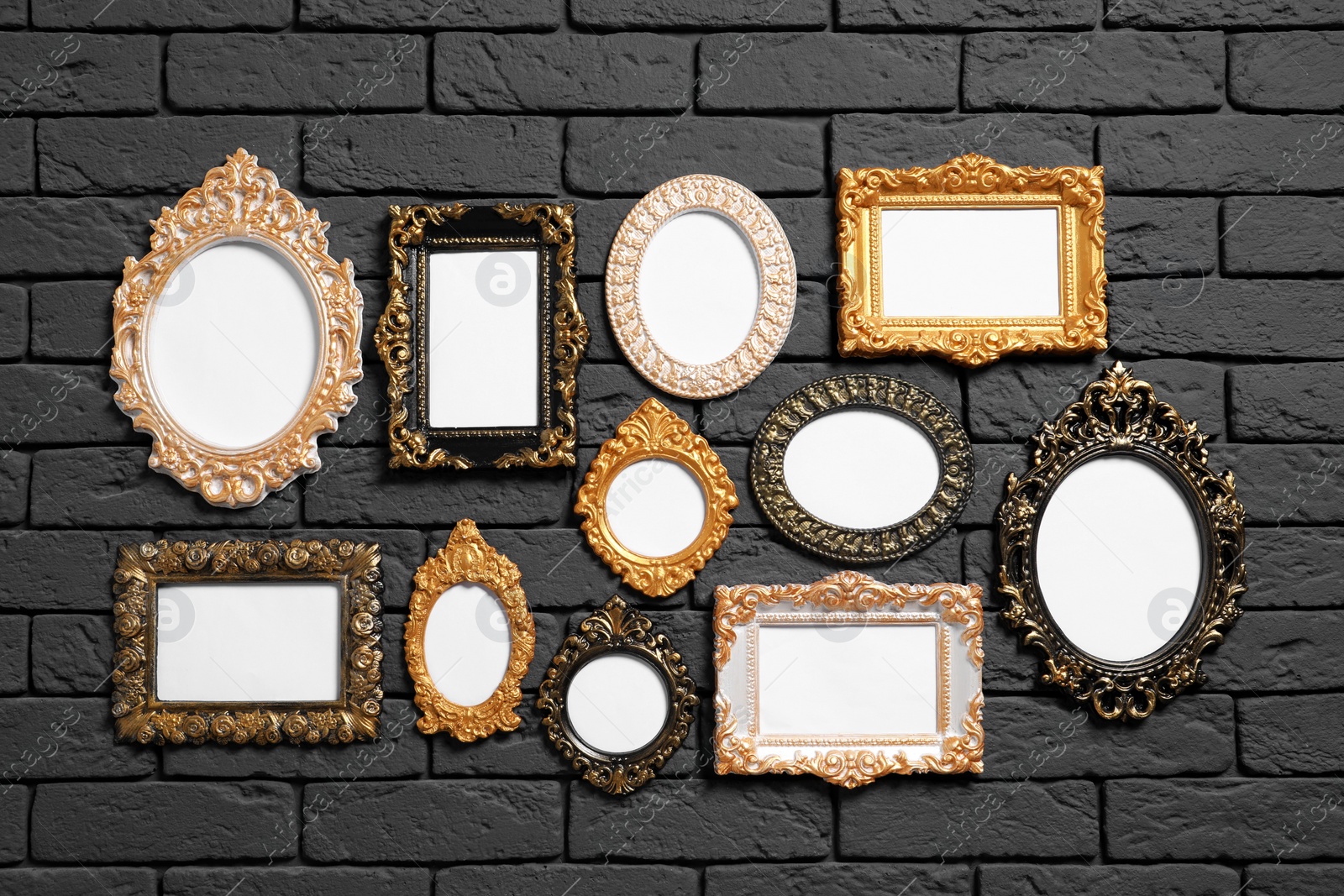 Photo of Empty vintage frames hanging on dark brick wall. Mockup for design