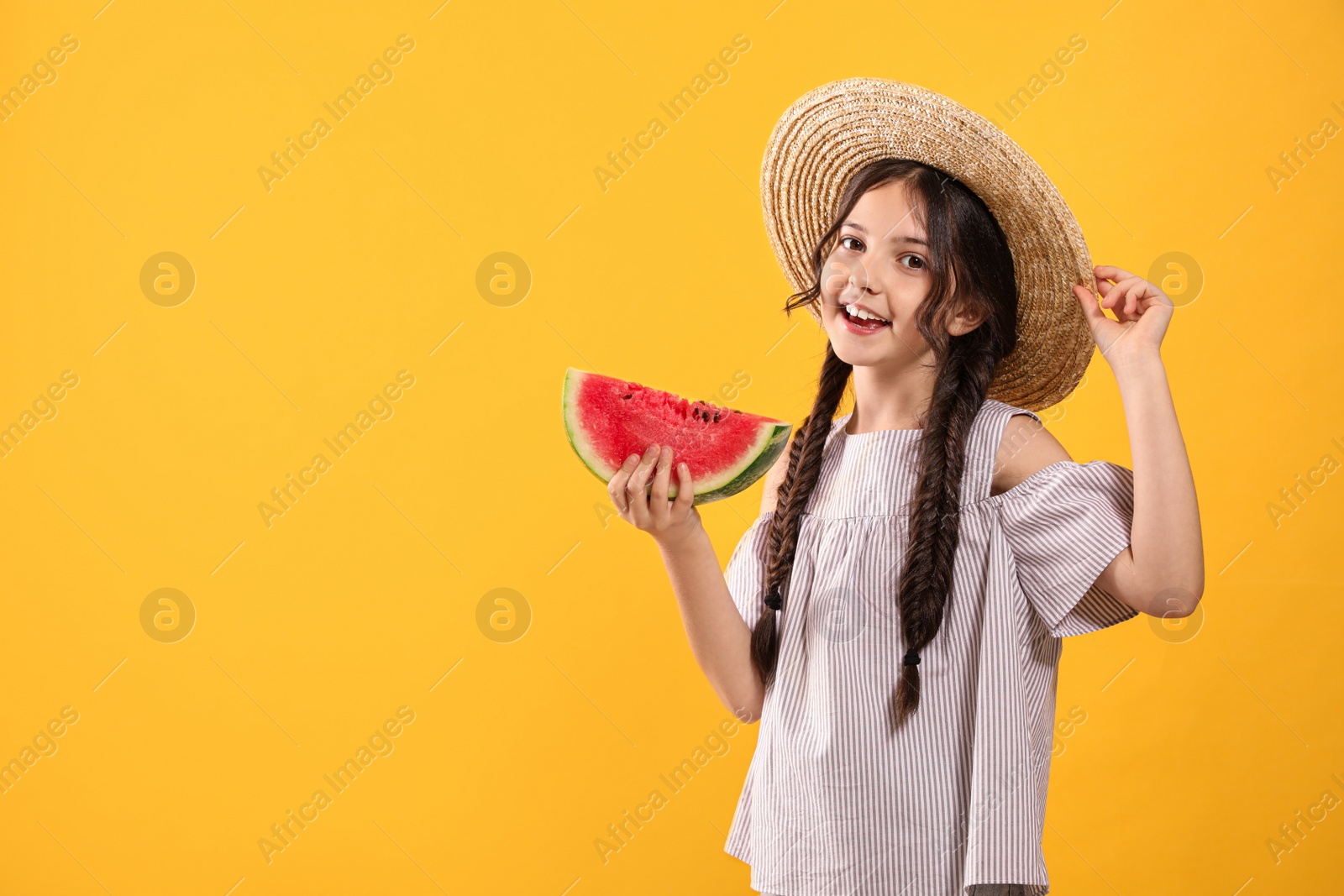 Photo of Cute little girl with watermelon on yellow background. Space for text