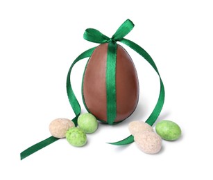 Photo of Tasty chocolate egg with green bow and different candies isolated on white