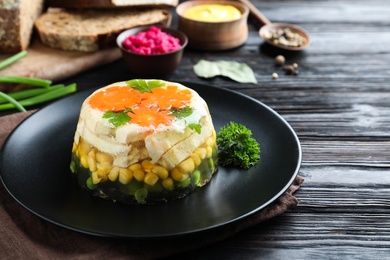 Photo of Delicious homemade chicken aspic on black wooden table