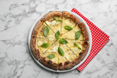 Tasty cheese pizza with basil on white marble table, top view