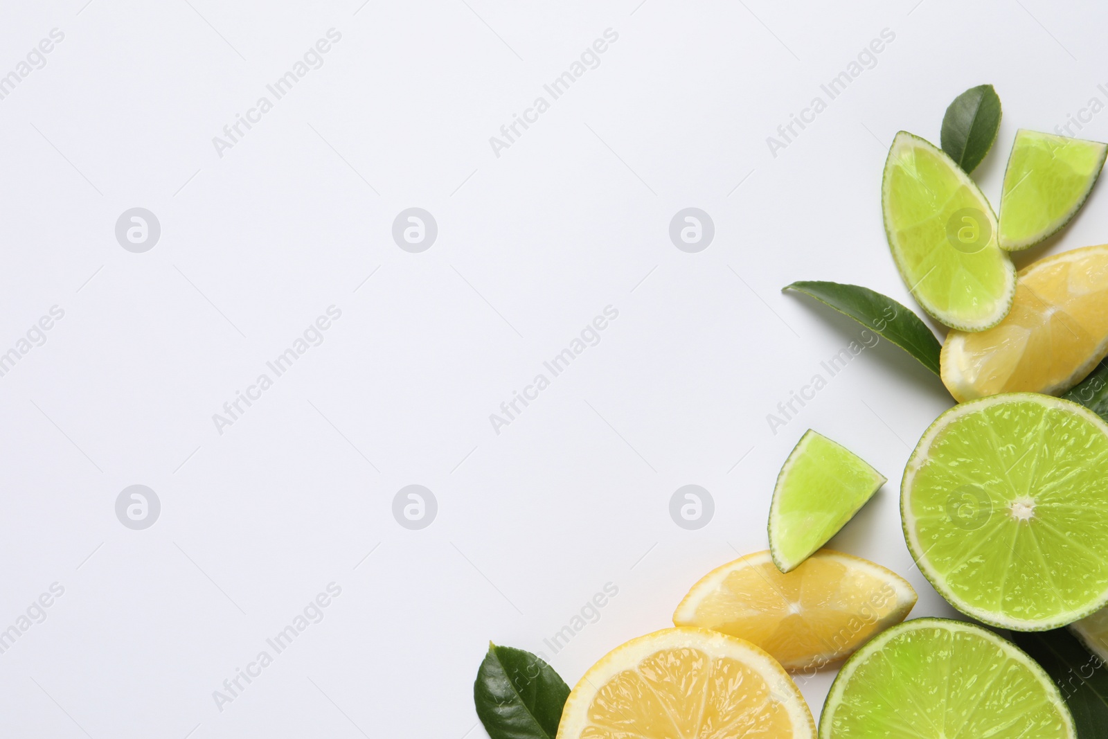 Photo of Fresh ripe lemons, limes and green leaves on white background, top view