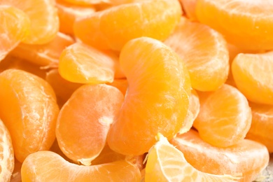 Pieces of ripe tangerines as background, closeup