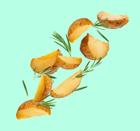 Image of Tasty baked potatoes and rosemary falling on cyan background
