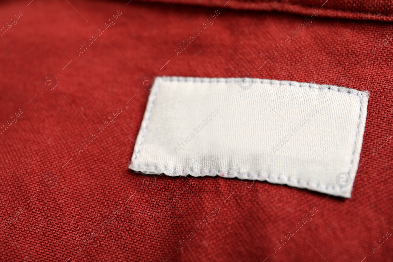 Photo of Blank clothing label on red shirt, closeup