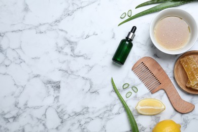 Homemade hair mask in bowl, ingredients and comb on white marble table, flat lay. Space for text