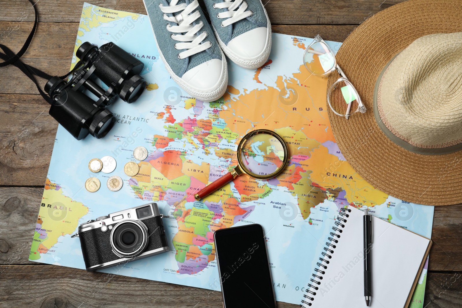 Photo of Flat lay composition with world map and different travel accessories on wooden table. Planning summer vacation trip