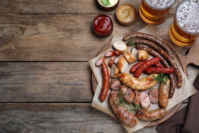 Set of different tasty snacks and beer on wooden table, flat lay. Space for text