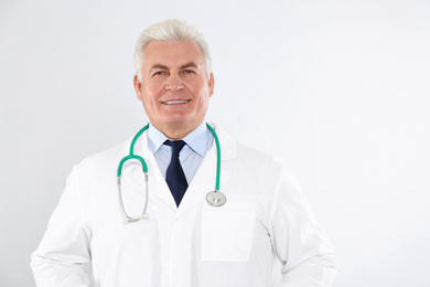 Photo of Portrait of senior doctor with stethoscope on white background