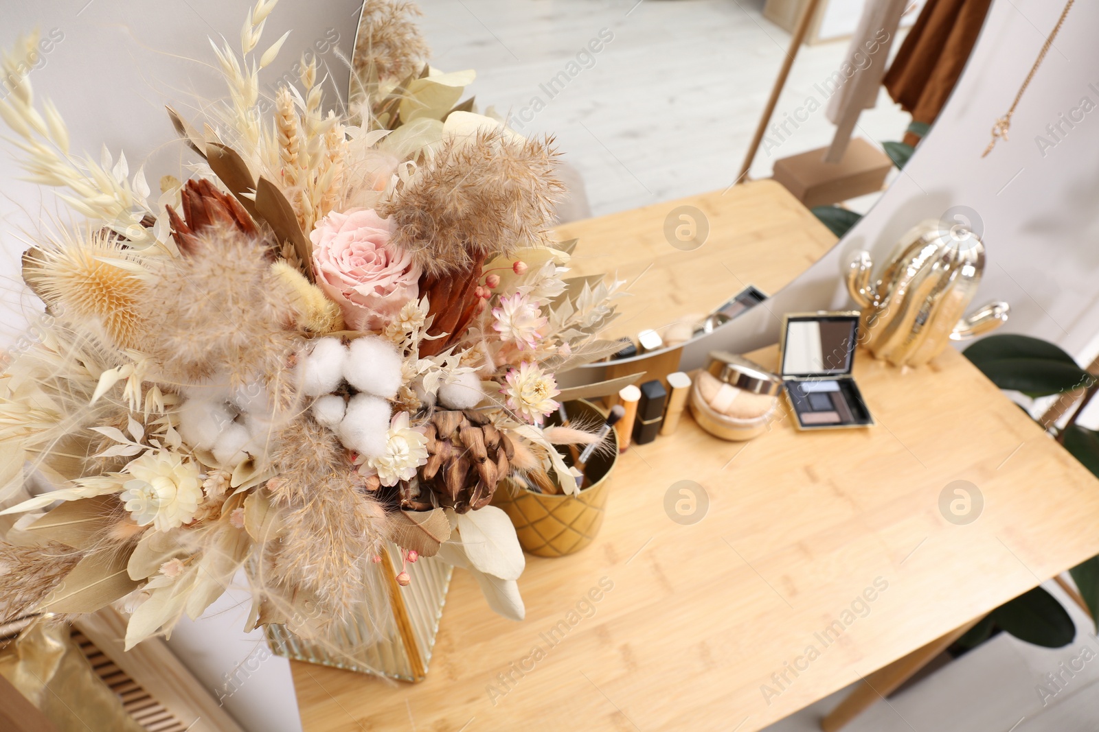 Photo of Modern dressing table with decorative elements and makeup products indoors, view from above