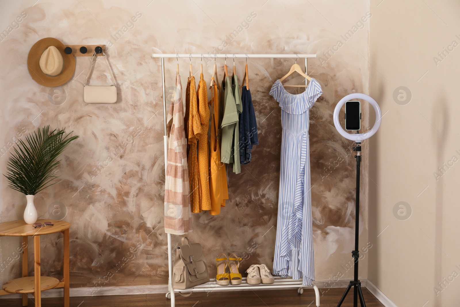 Photo of Taking photo of stylish clothes hanging on rack indoors