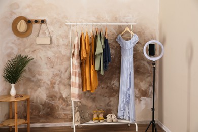 Taking photo of stylish clothes hanging on rack indoors