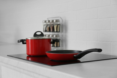 Saucepot and frying pan on induction stove in kitchen