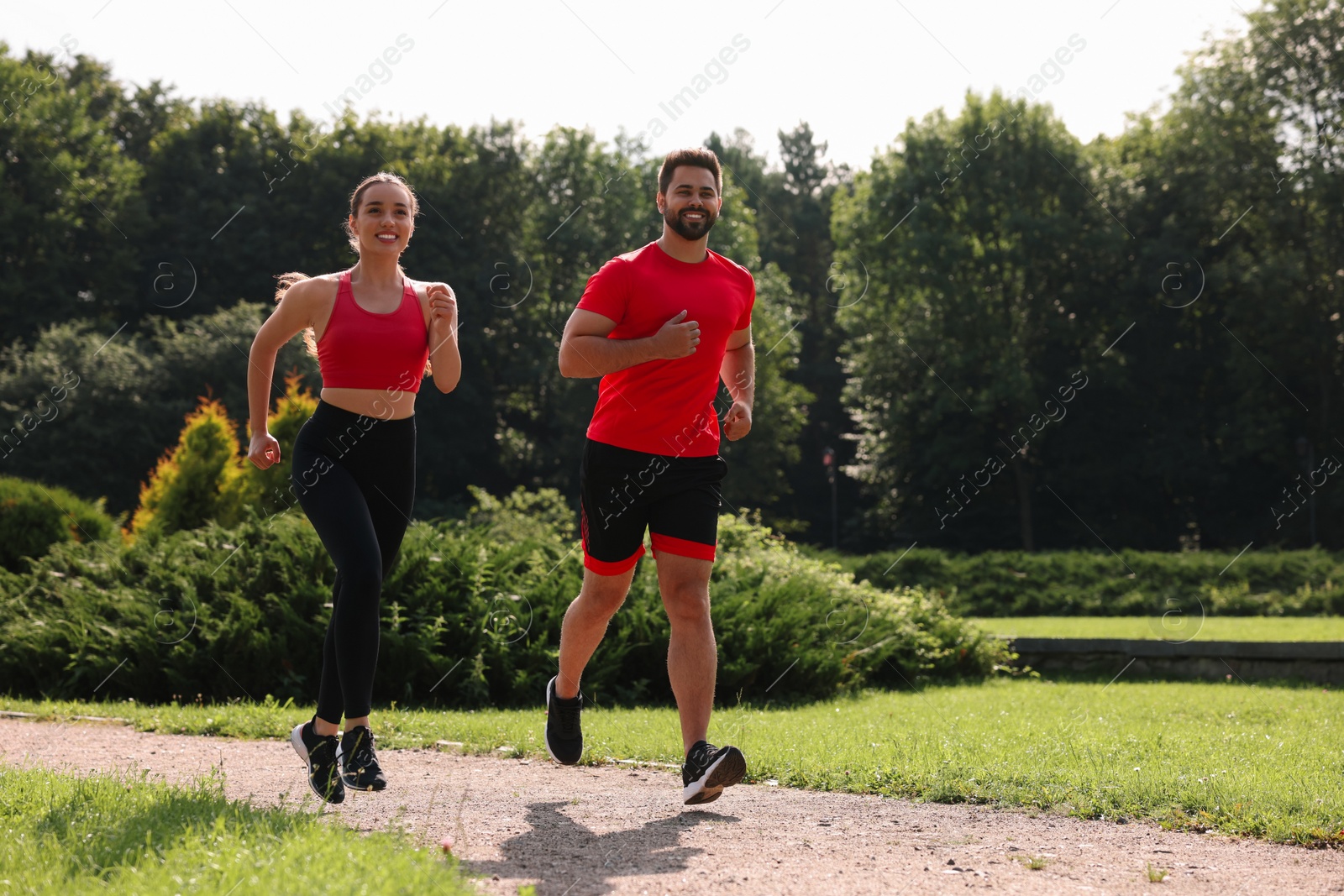 Photo of Healthy lifestyle. Happy couple running in park on sunny day, space for text