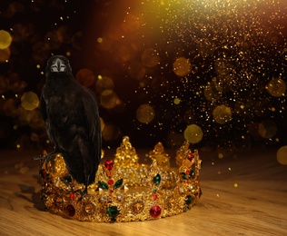 Fantasy world. Black crow lit by magic light sitting on golden crown, bokeh effect