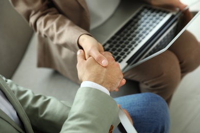 Photo of Business partners shaking hands after meeting, closeup