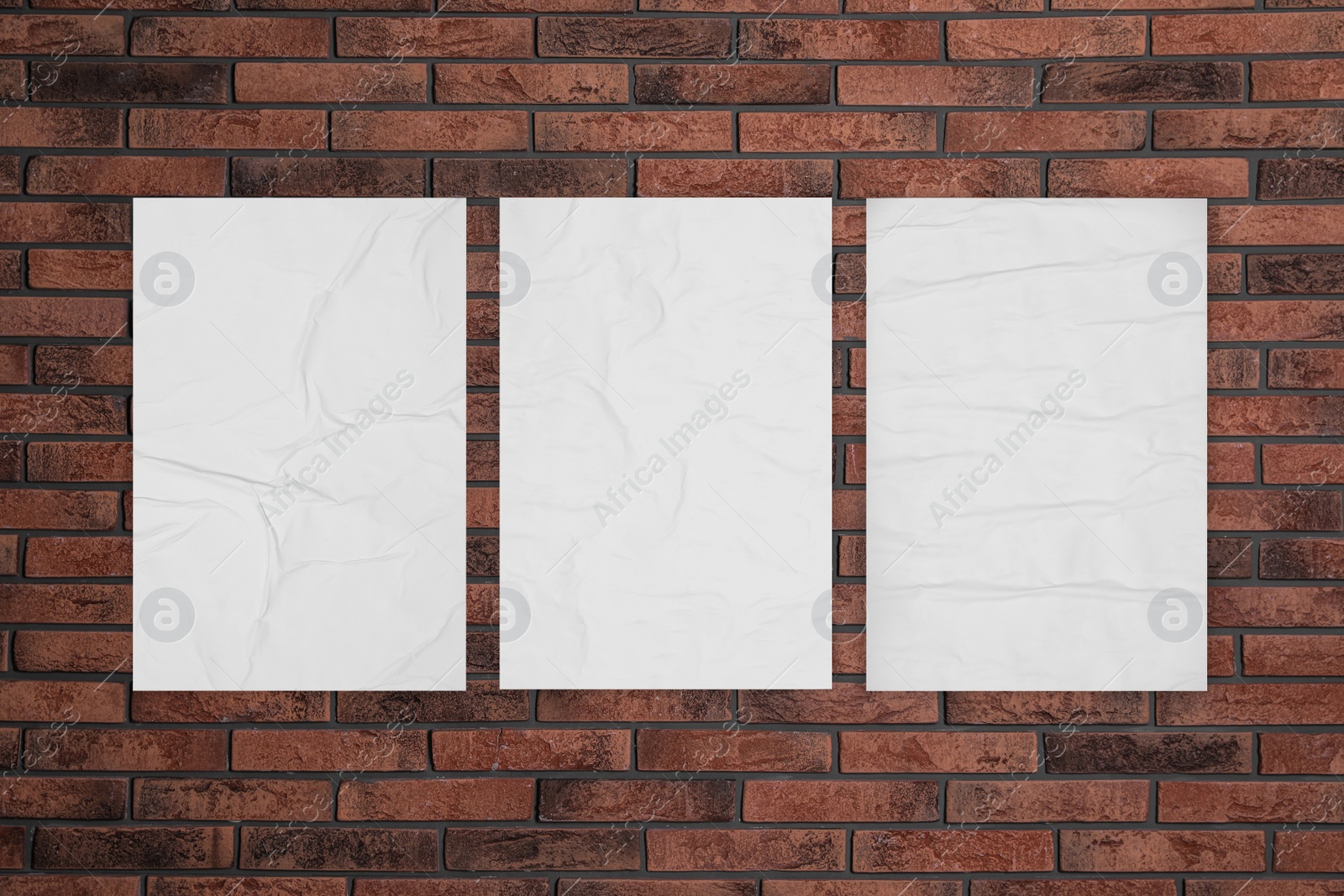 Image of Blank creased posters on brick wall. Mockup for design 