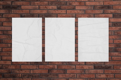 Image of Blank creased posters on brick wall. Mockup for design 