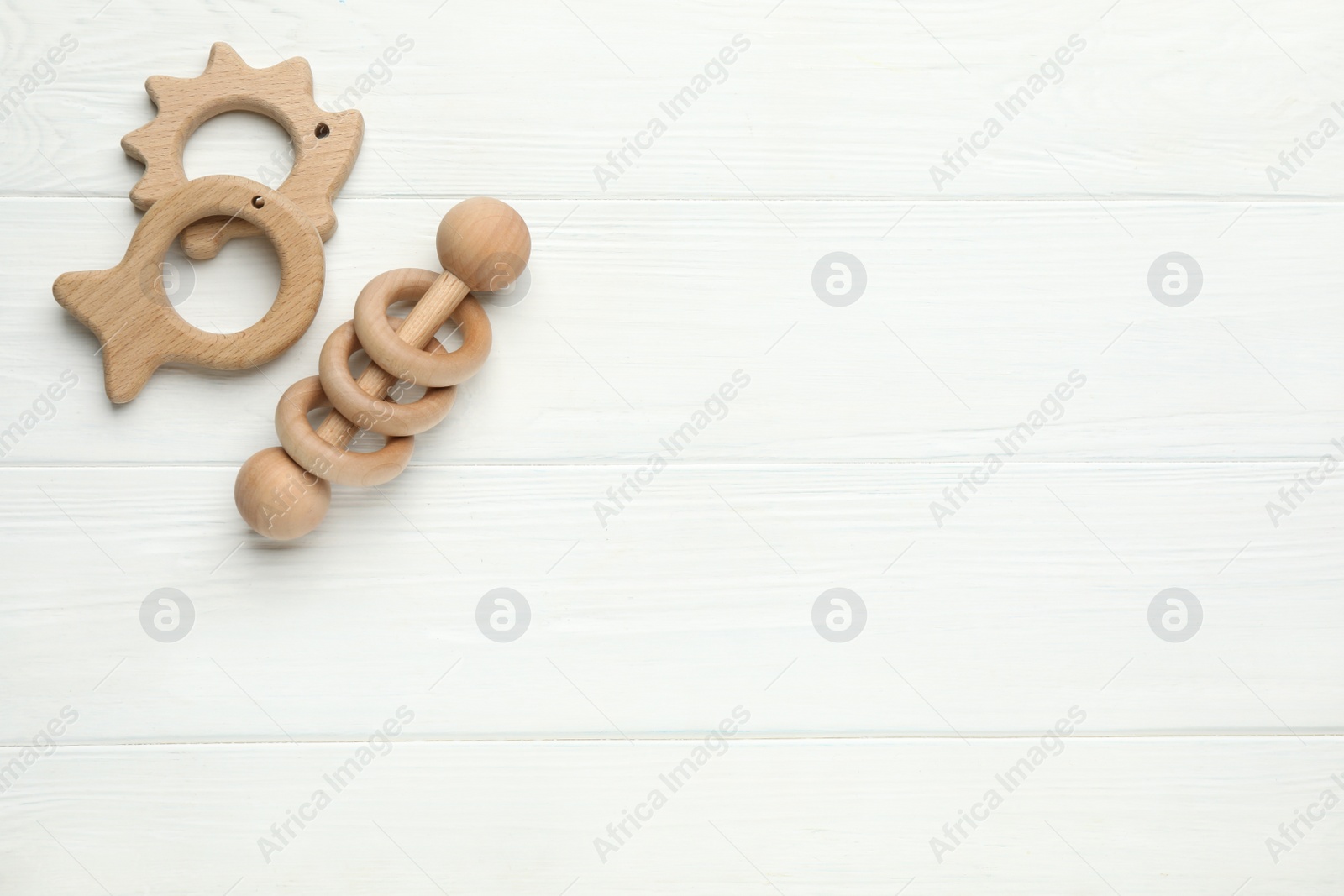 Photo of Cute baby toys on white wooden background, flat lay. Space for text