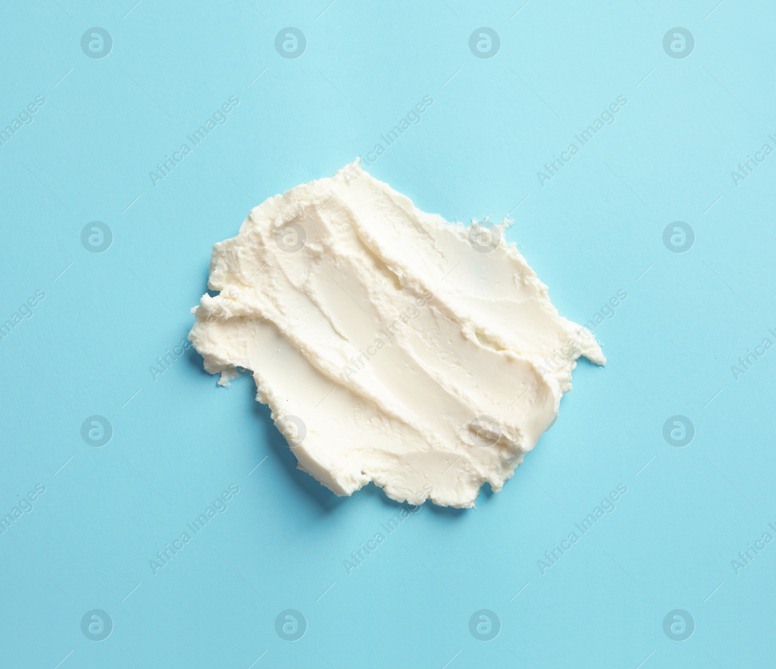 Photo of Smear of tasty cream cheese on color background, top view