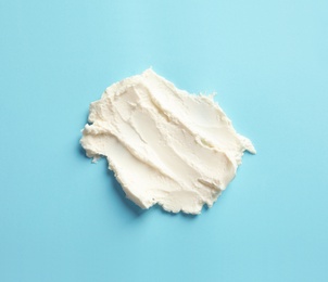 Smear of tasty cream cheese on color background, top view