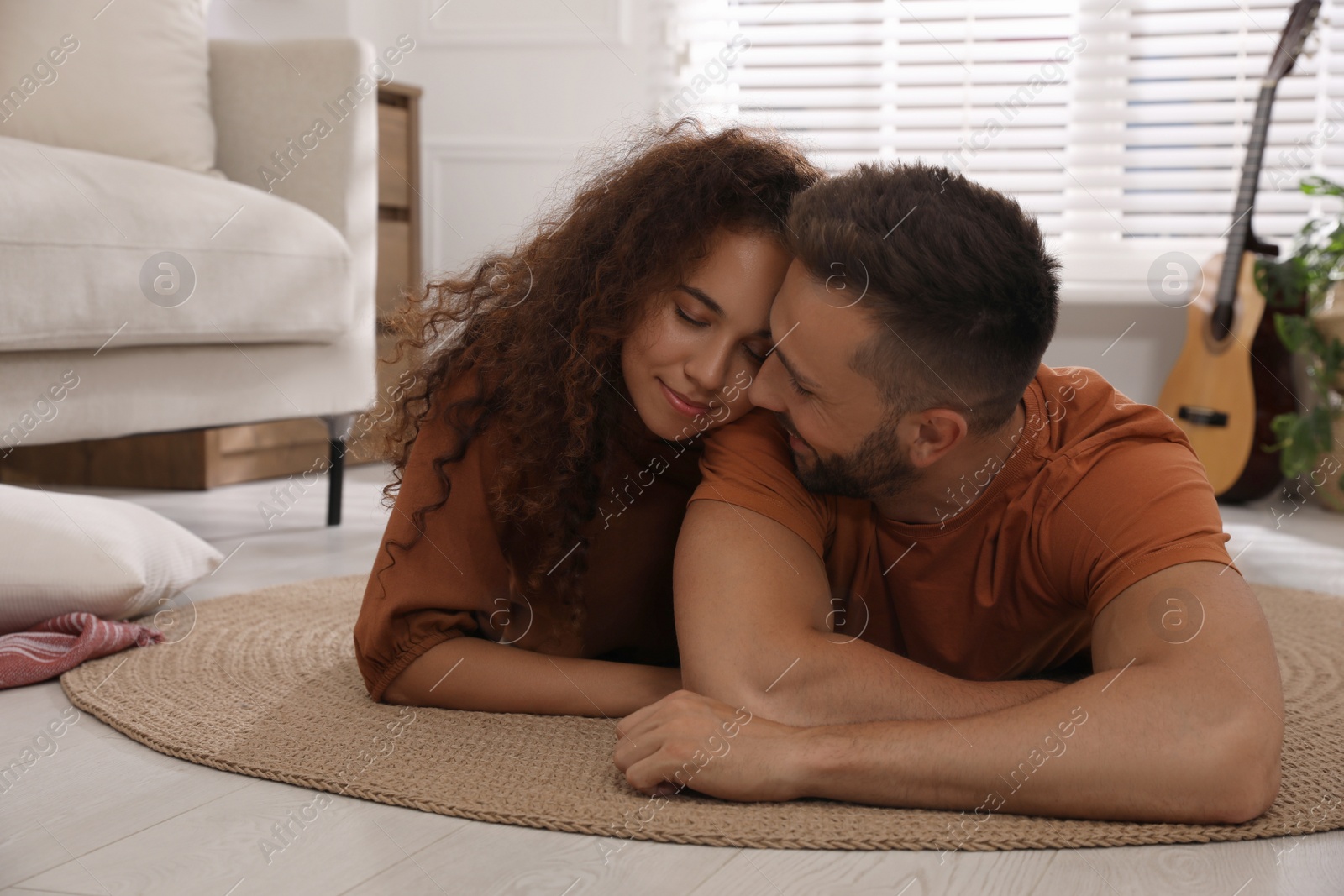 Photo of Lovely couple enjoying each other on floor in living room