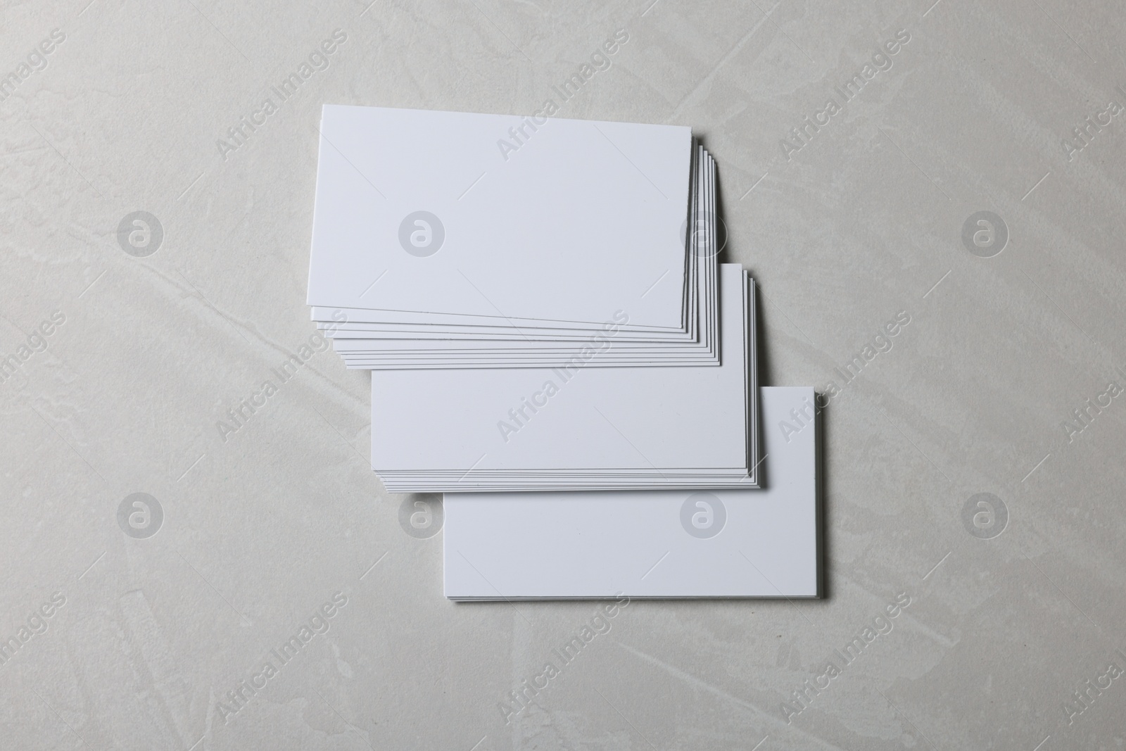 Photo of Blank business cards on light grey textured background, top view. Mockup for design