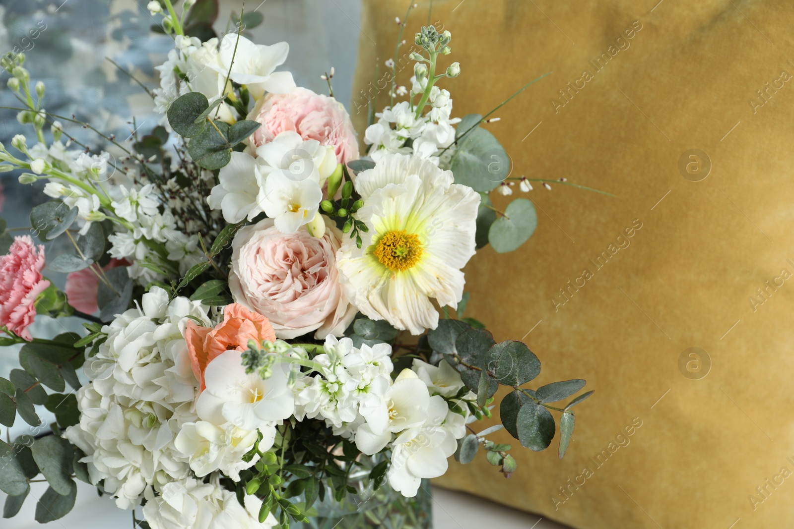 Photo of Bouquet of beautiful fresh flowers near pillow, closeup
