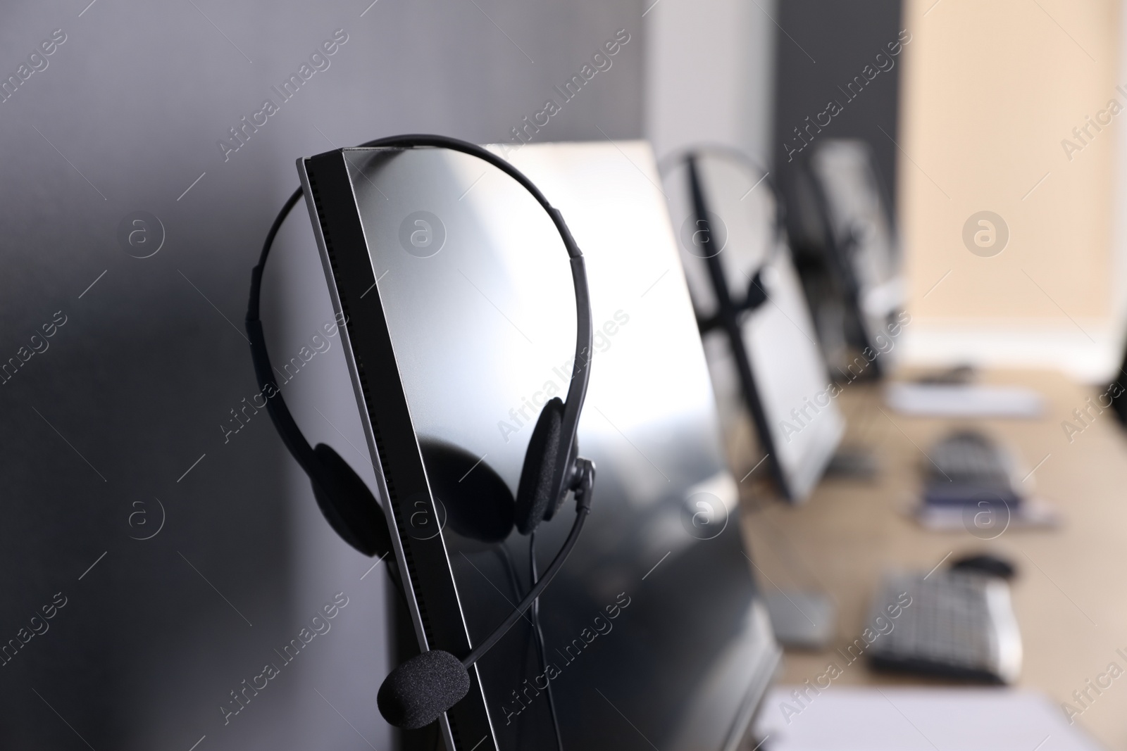 Photo of Modern computer with headset in office. Hotline service