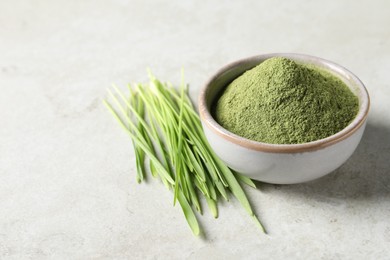 Wheat grass powder in bowl and fresh sprouts on light table