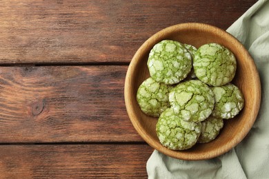 Photo of Bowl with tasty matcha cookies on wooden table, top view. Space for text