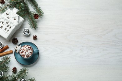 Delicious hot chocolate with marshmallows and Christmas decor on white wooden table, flat lay. Space for text