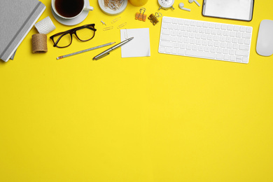 Flat lay composition with computer accessories and different office items on yellow background, space for text. Designer's workplace