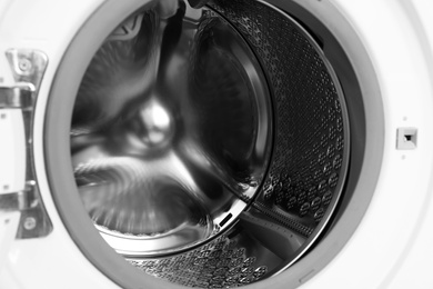 Photo of Empty washing machine drum, closeup. Laundry day