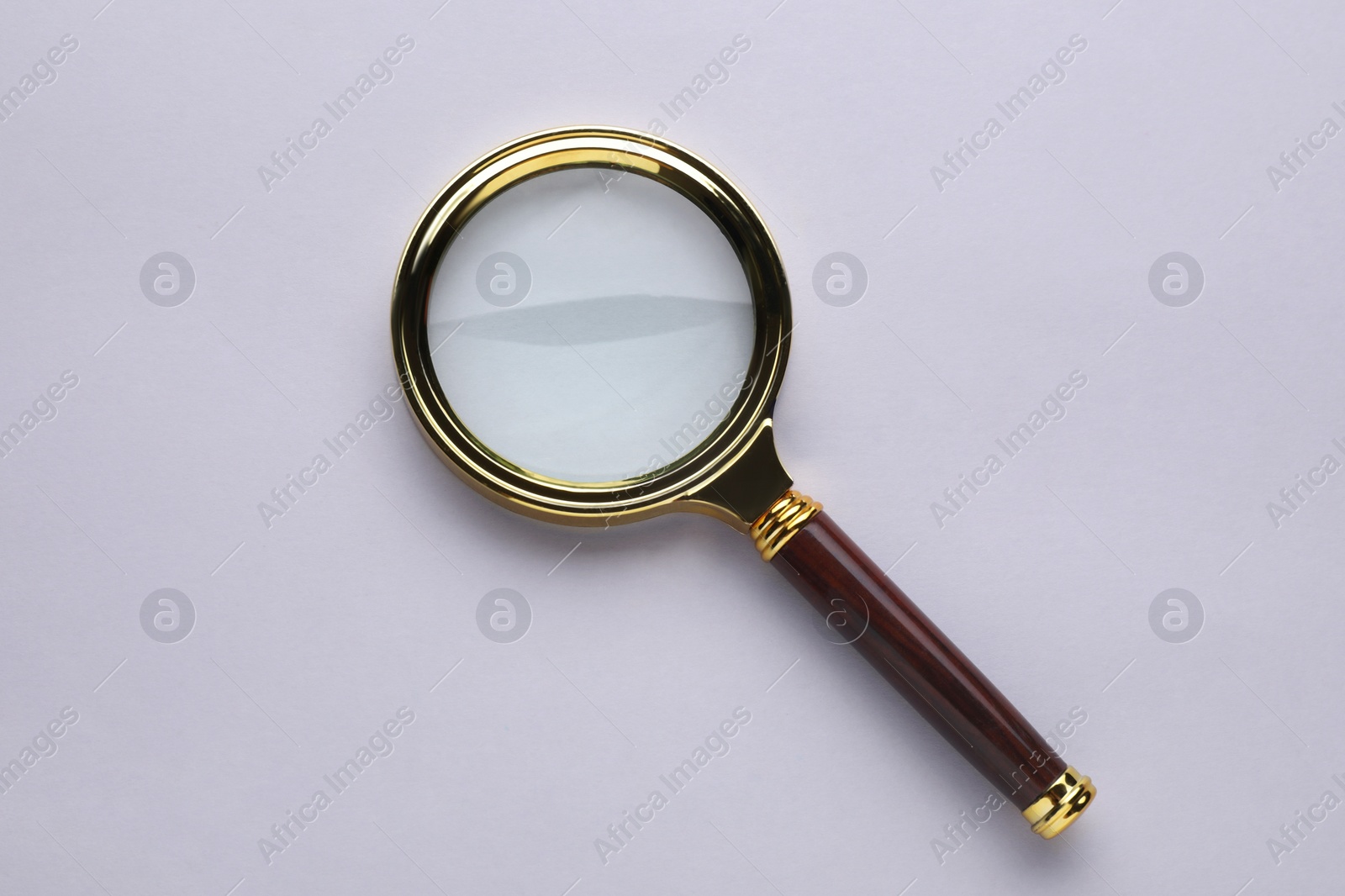 Photo of Magnifying glass on light grey background, top view