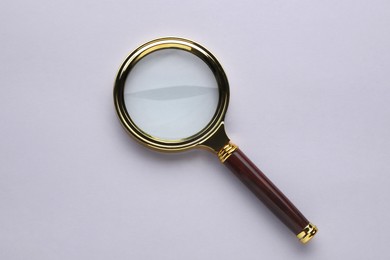 Magnifying glass on light grey background, top view