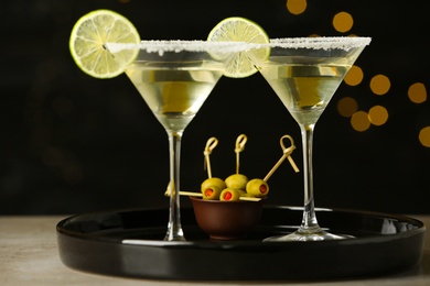 Glasses of Lime Drop Martini cocktail on grey table against blurred background