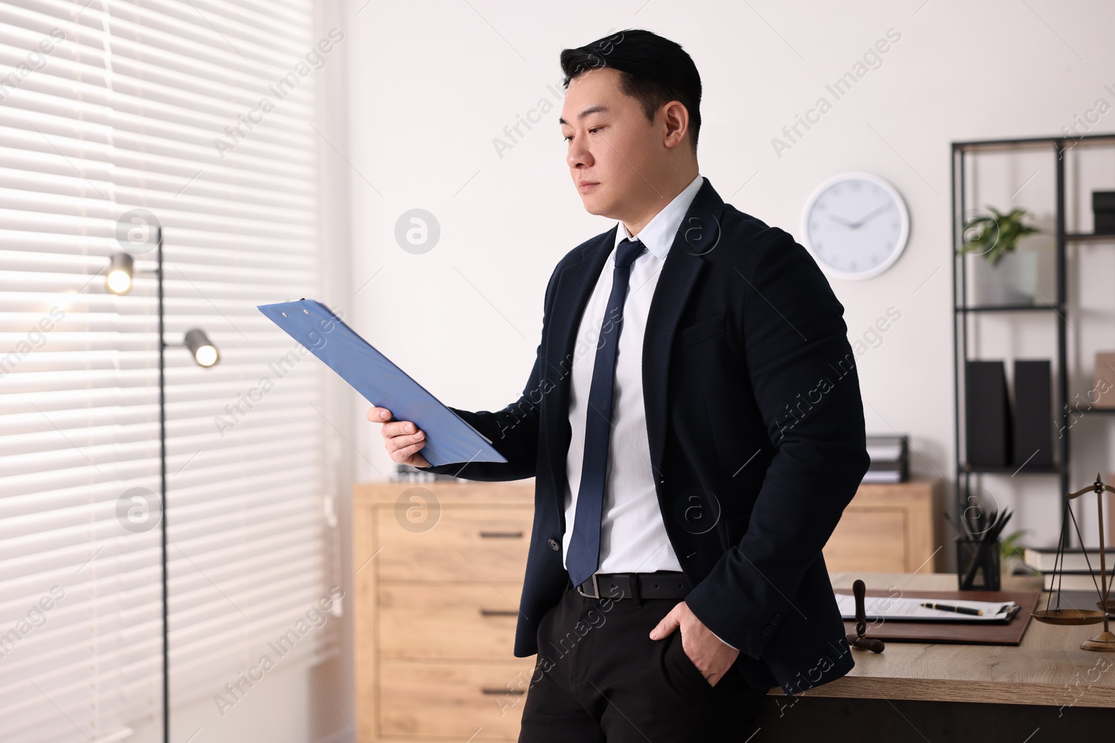 Photo of Portrait of confident notary with clipboard in office