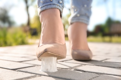 Woman stepping in chewing gum on sidewalk. Concept of stickiness