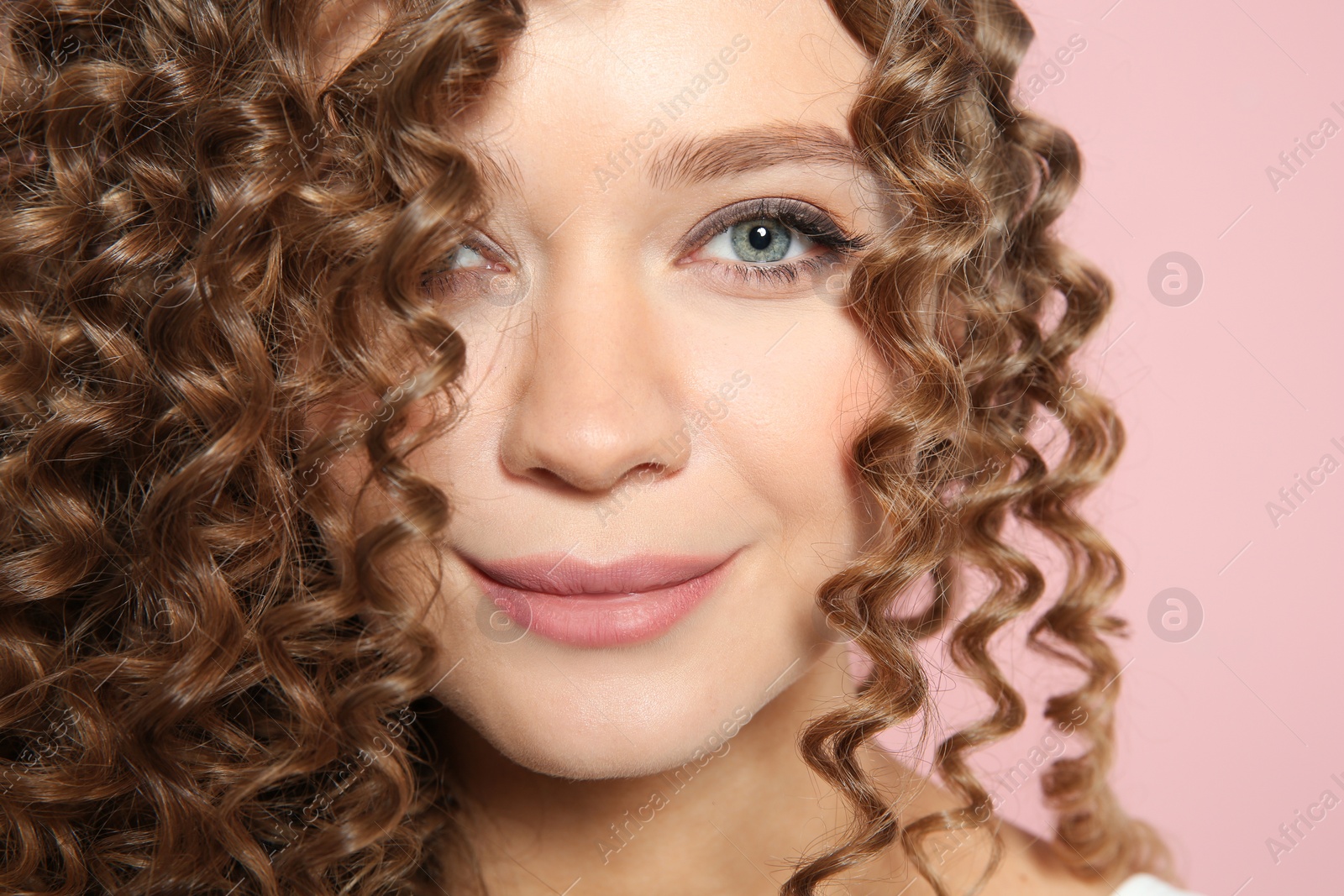 Photo of Portrait of beautiful young woman with shiny wavy hair on color background, closeup