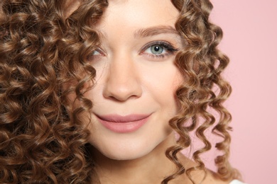 Portrait of beautiful young woman with shiny wavy hair on color background, closeup