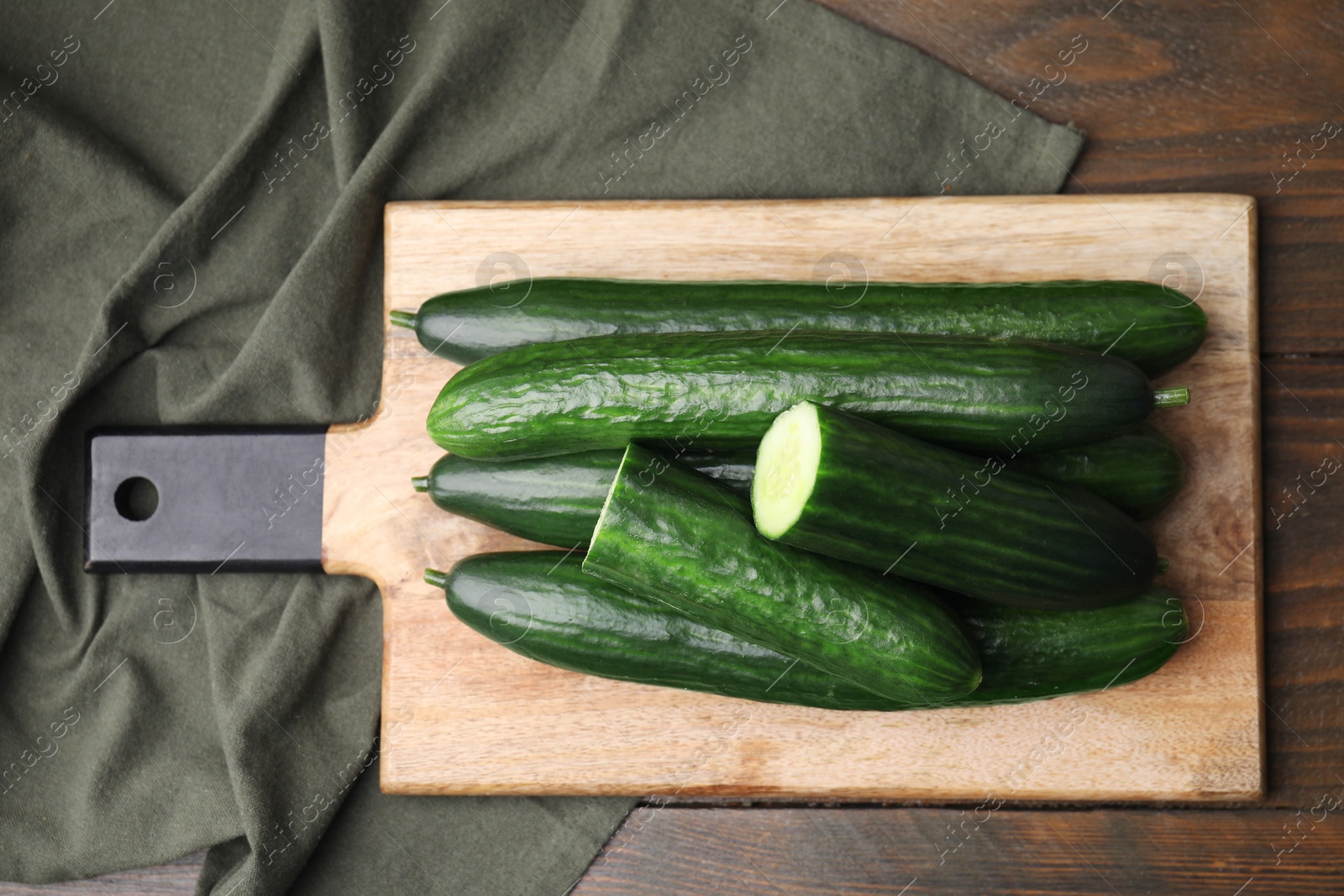 Photo of Fresh cucumbers on wooden table, top view