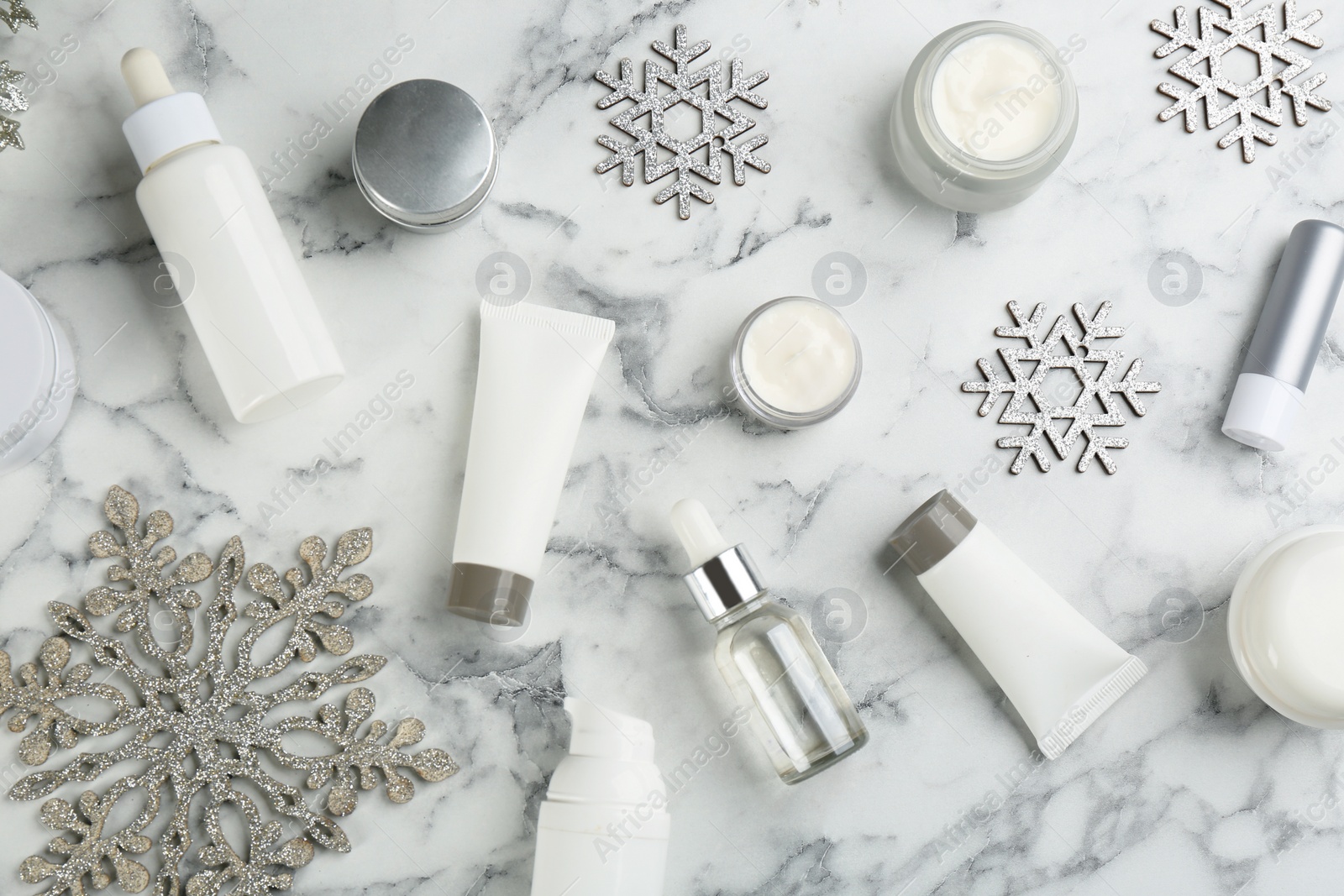 Photo of Flat lay composition with different cosmetic products on white marble table. Winter care