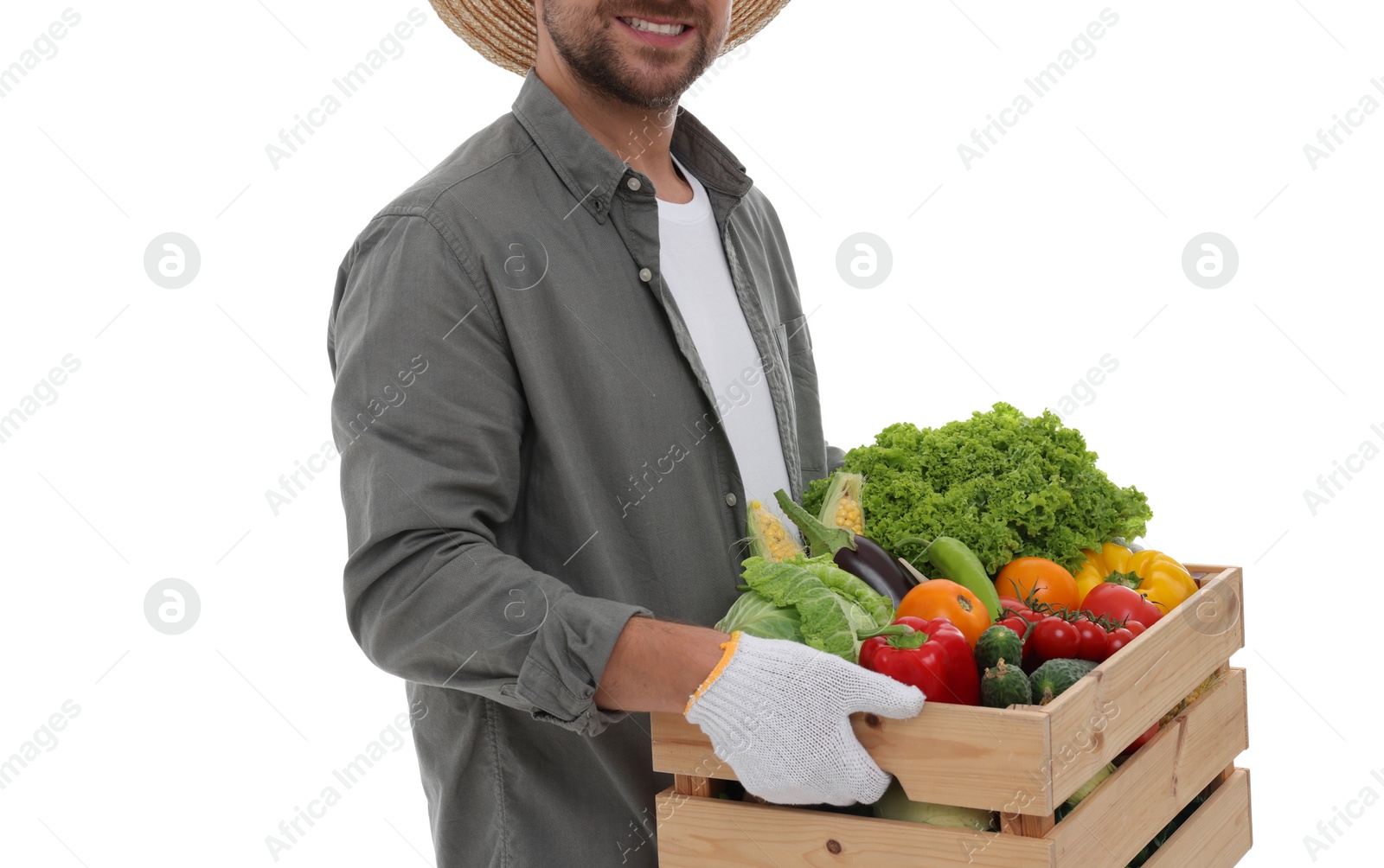 Photo of Harvesting season. Happy farmer holding wooden crate with vegetables on white background, closeup