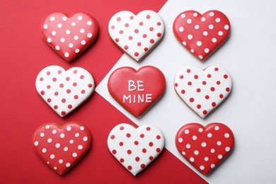 Photo of Decorated heart shaped cookies on color background, flat lay. Valentine's day treat