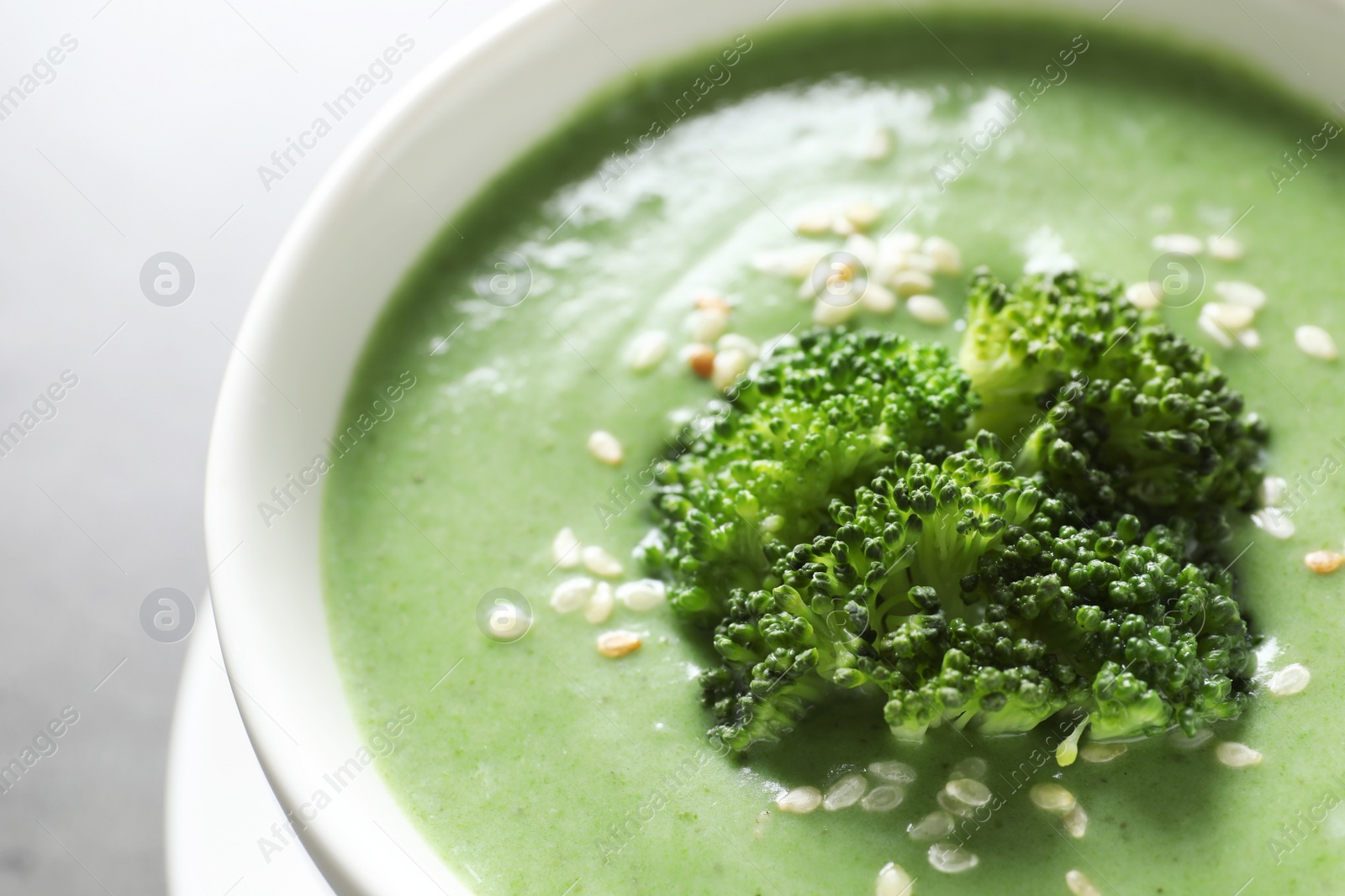 Photo of Fresh vegetable detox soup made of broccoli in dish on table, closeup