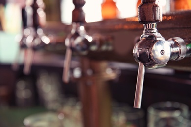 Photo of Beer taps at counter in bar, closeup