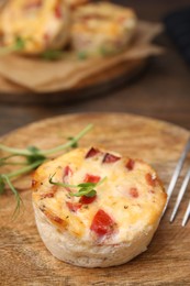 Photo of Delicious egg muffin with cheese and bacon on wooden table, closeup. Space for text