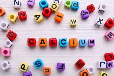 Word Calcium made of colorful plastic beads with letters, top view