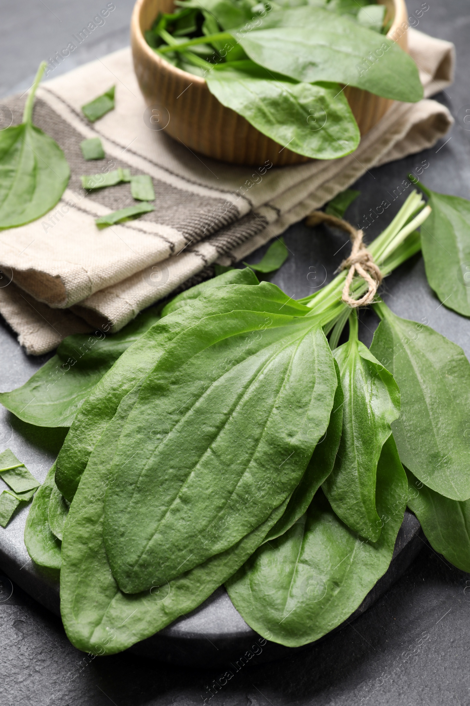 Photo of Broadleaf plantain leaves on black slate table